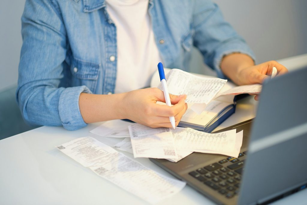 woman holding the bills to calculate in living room at home. Expenses, account, taxes, home budget